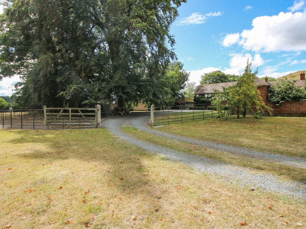 An outdoor area with a pathway and fence at The Coach House in Little Stretton