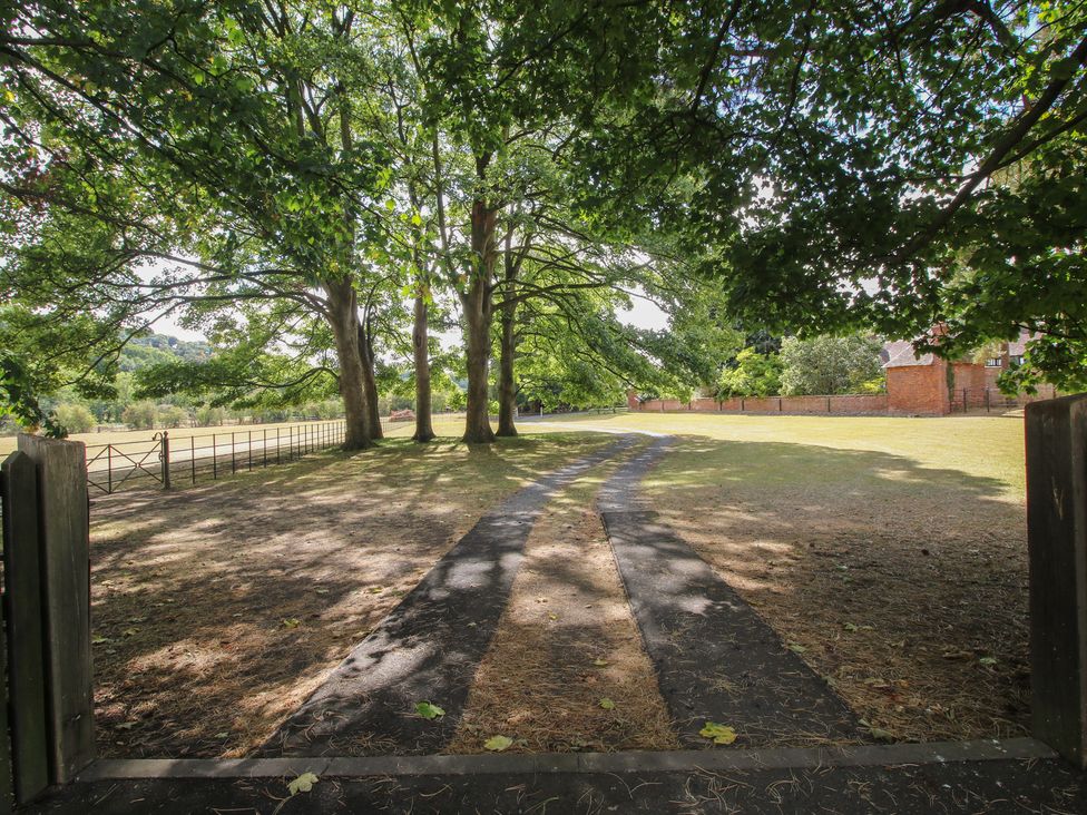 A pathway leading through trees at The Coach House in Little Stretton