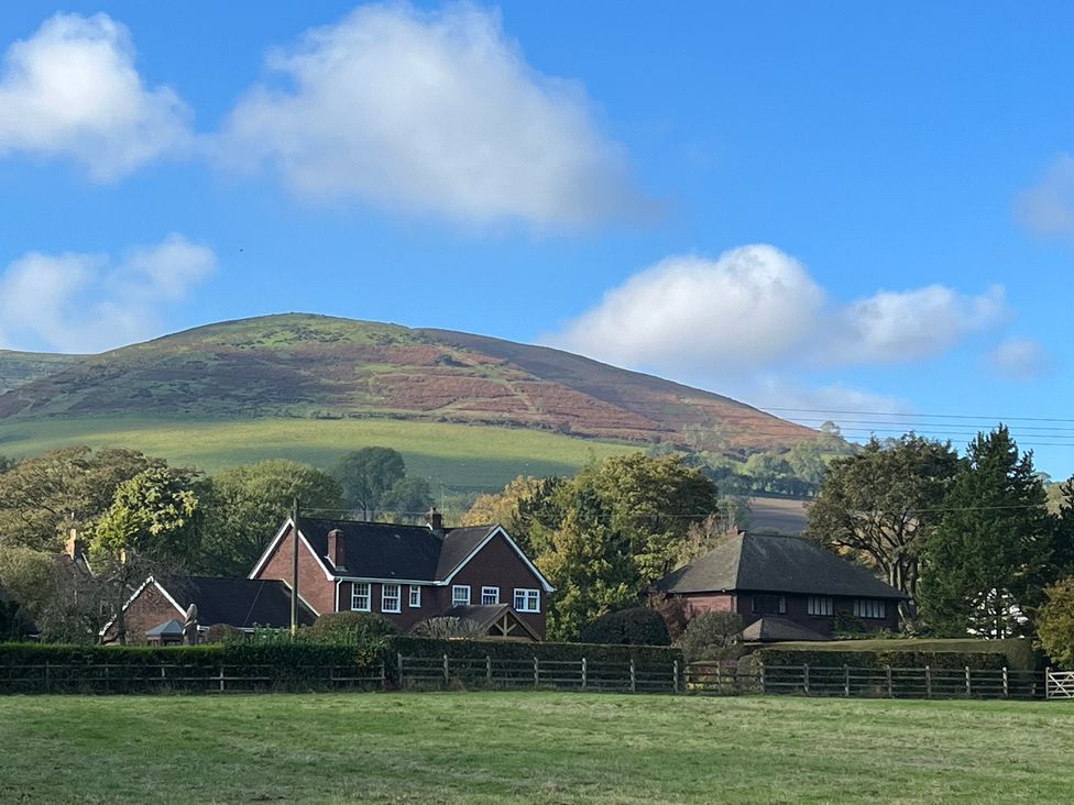 A view of houses and a hill in the background at The Coach House in Little Stretton