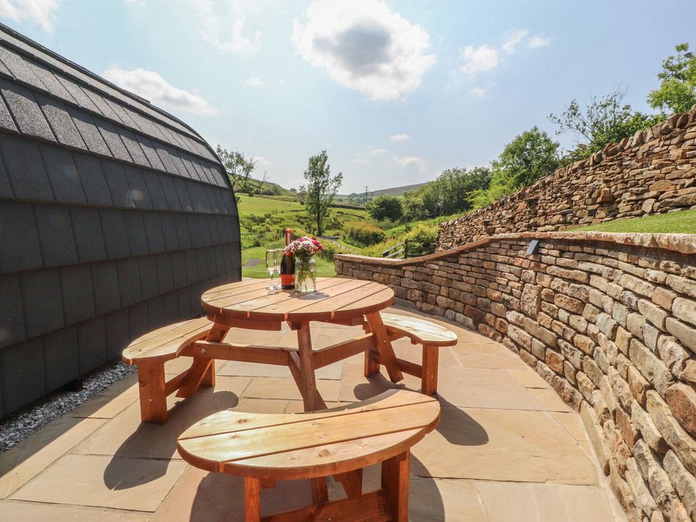 An outdoor seating area with a wooden table and benches at Pendle in Nelson