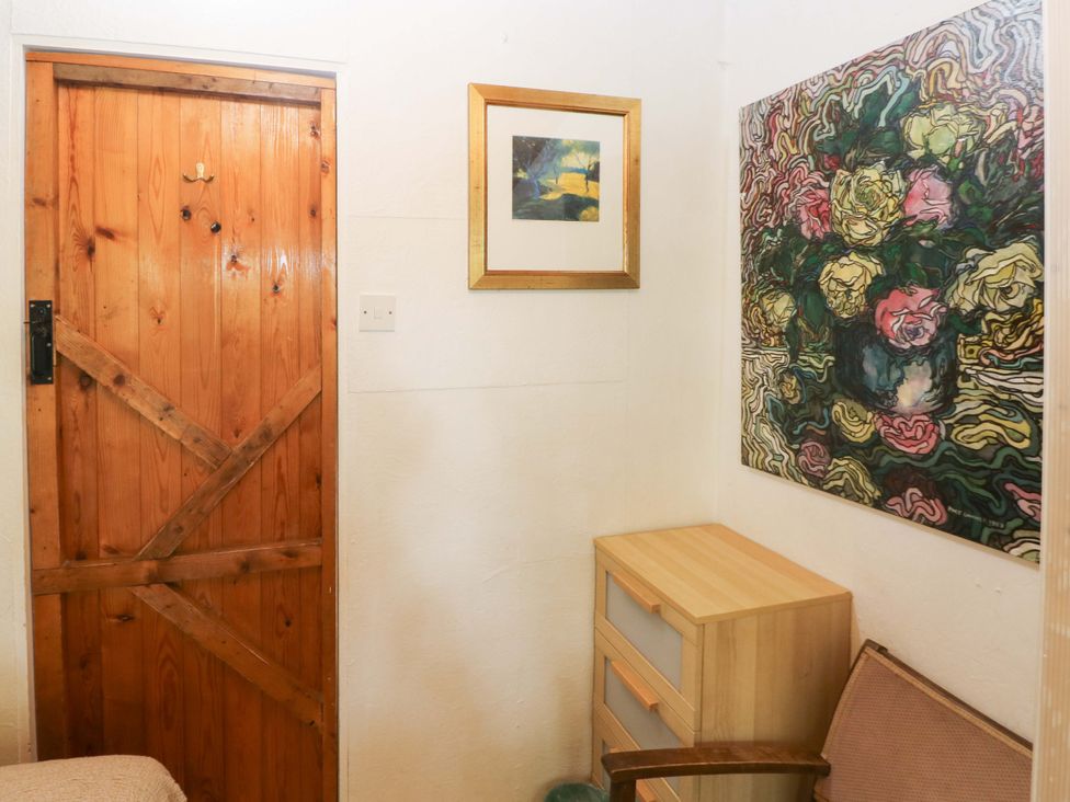 A room with a wooden door and a drawer unit at The Tree House in Nine Wells near Solva