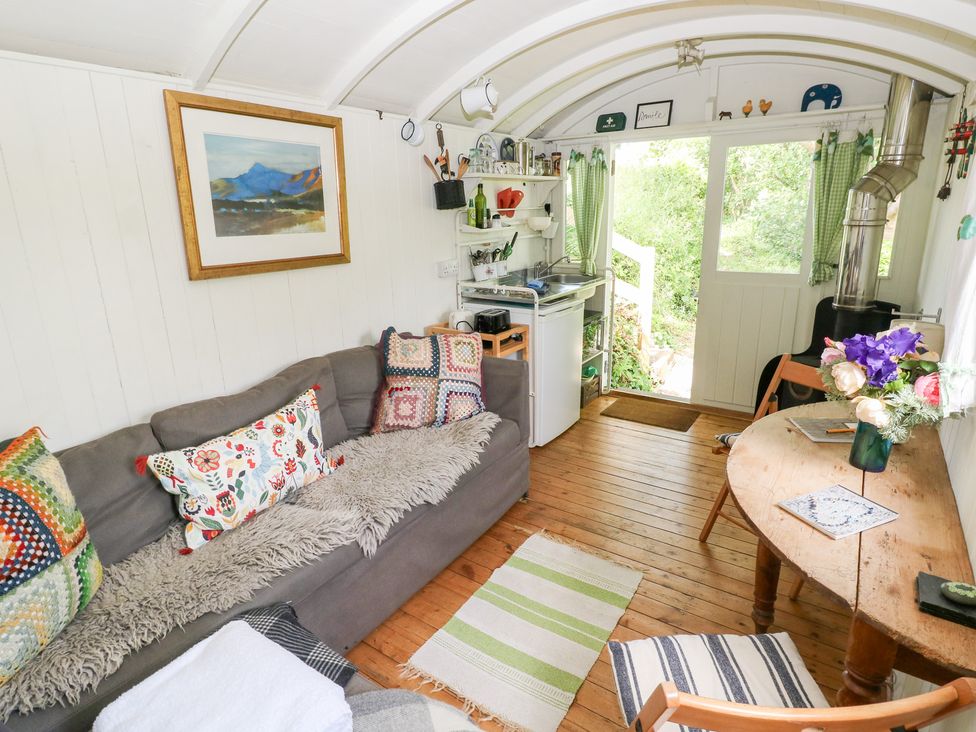 A living room with a couch and a table at The Shephard Hut in Nine Wells near Solva