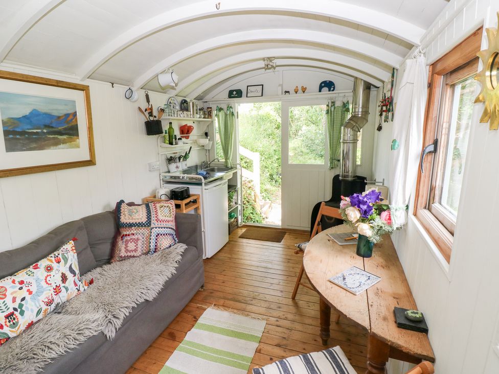 A living room with a sofa and table at The Shephard Hut Nine Wells near Solva