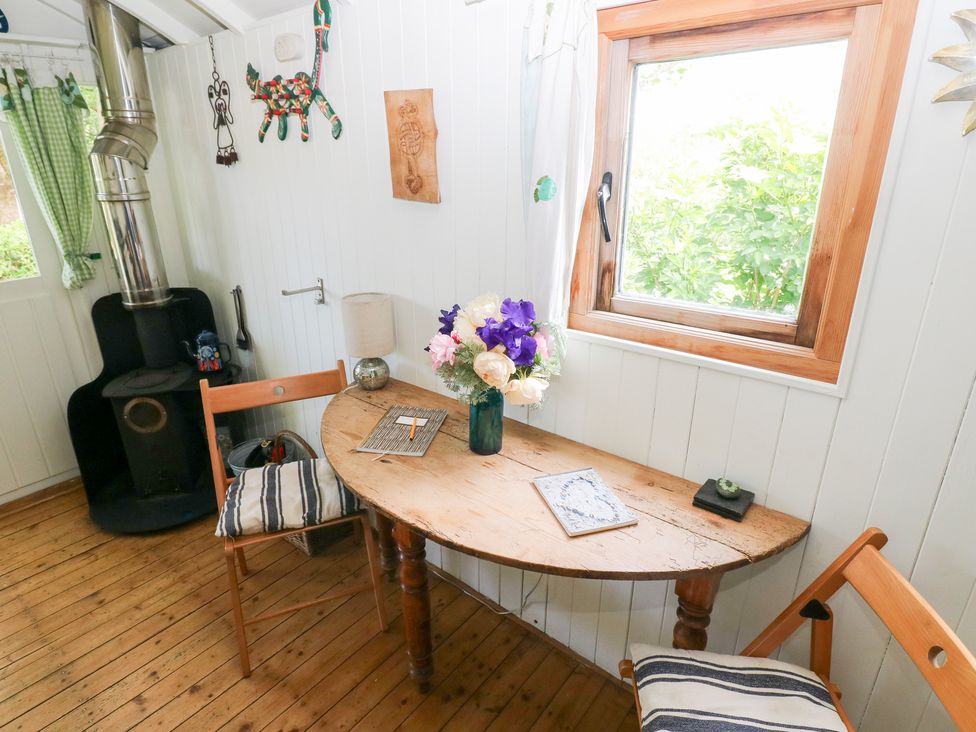 A snug with a wooden table and chairs at The Shephard Hut near Solva