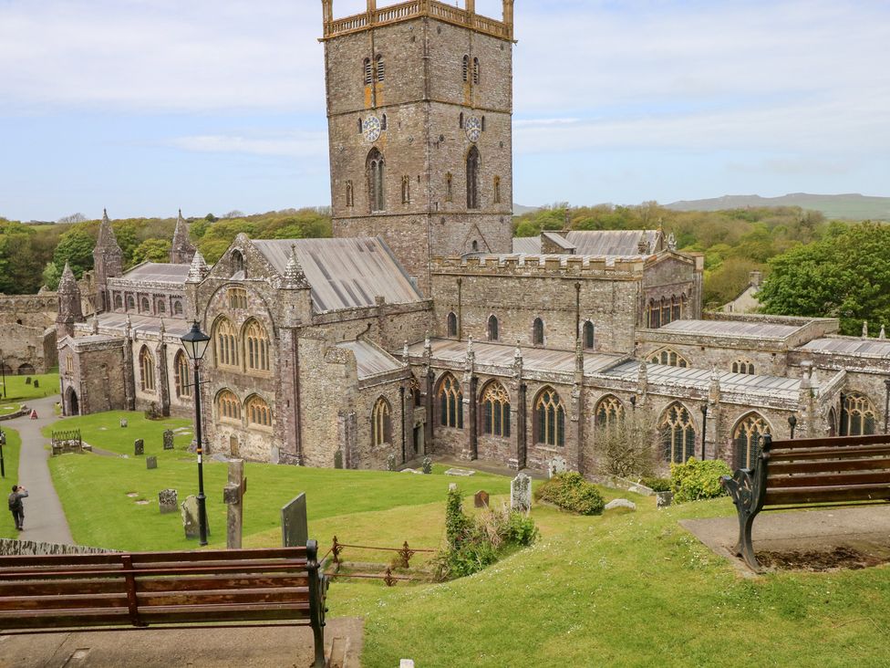 An outdoor area with a church and surrounding gravestones at The Shephard Hut near Nine Wells