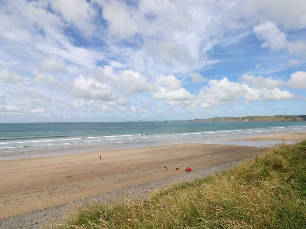 A beach with sand and sea at The Shephard Hut Nine Wells near Solva