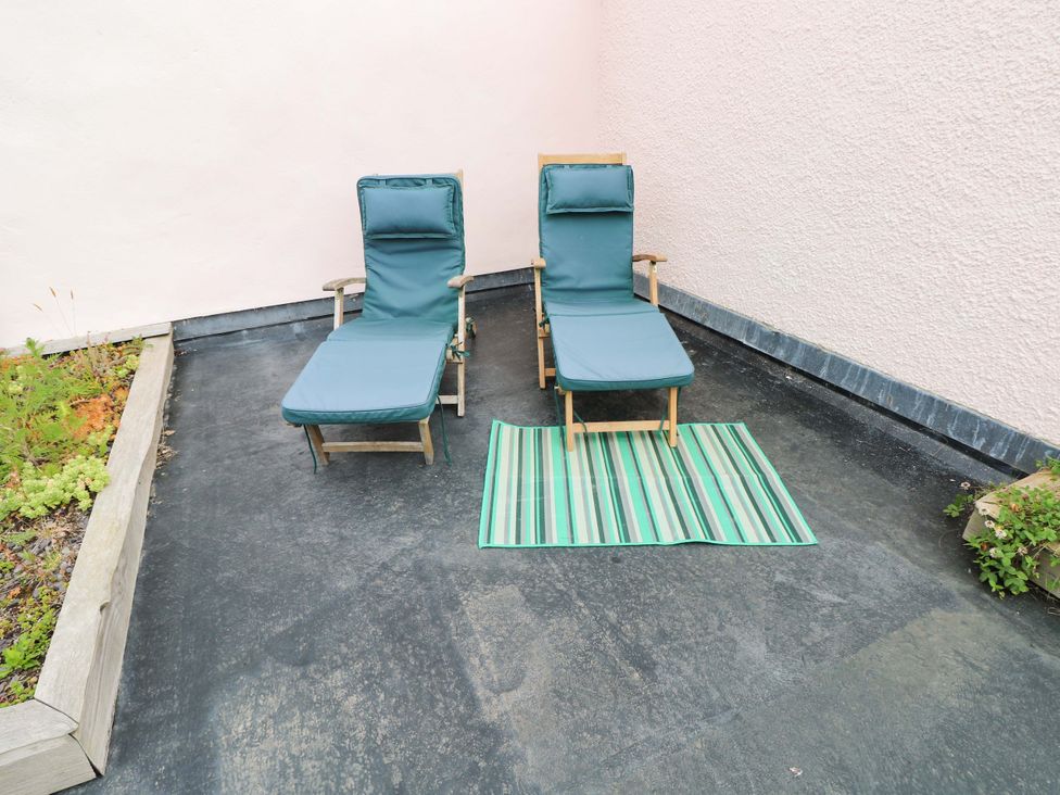 Two loungers and a striped mat in an outdoor area at The Tiny House Nine Wells near Solva