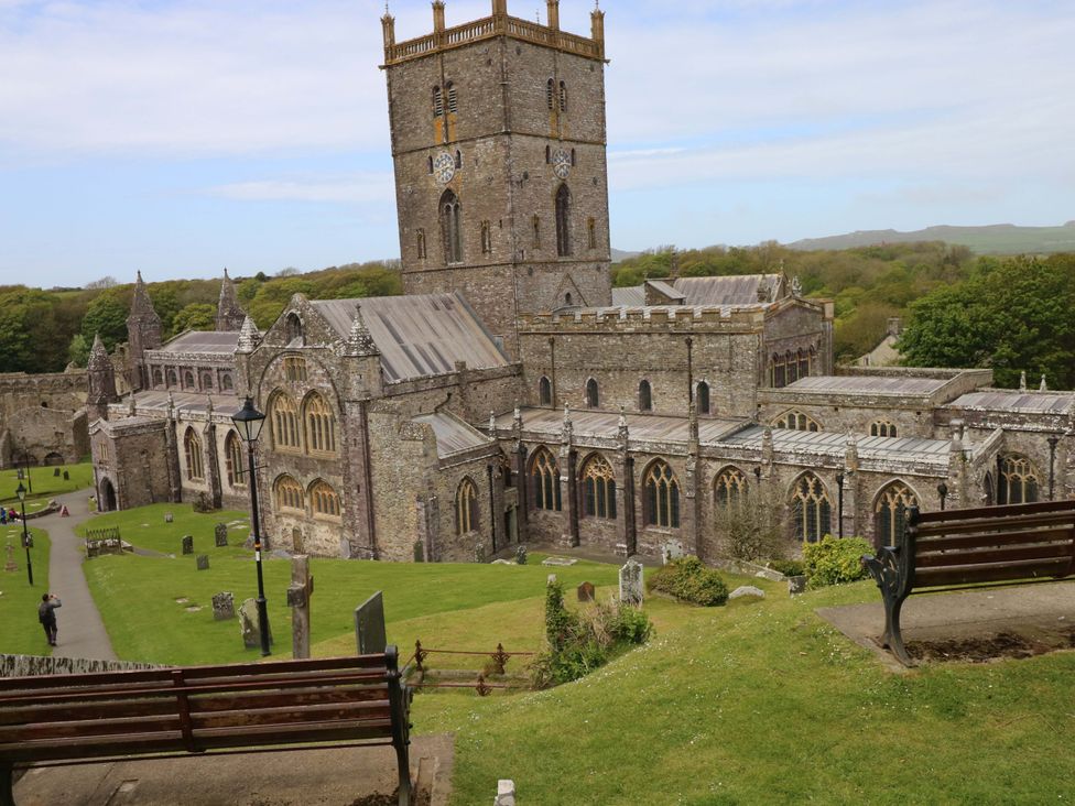 An old church with a tower and surrounding grounds at The Tiny House in Nine Wells near Solva