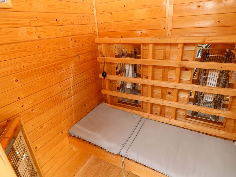 A small room with wooden walls and a mattress at The Tiny House in Nine Wells near Solva