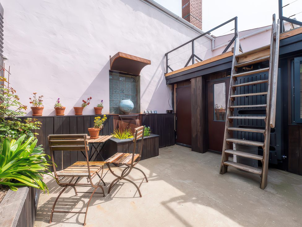 An outdoor area with a table and chairs at The Tiny House Nine Wells near Solva