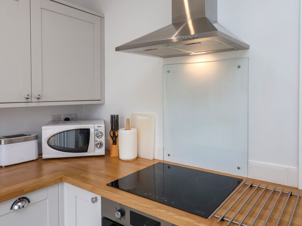 A kitchen with cabinets, microwave, and cooktop at 94 Church Street, Guisborough