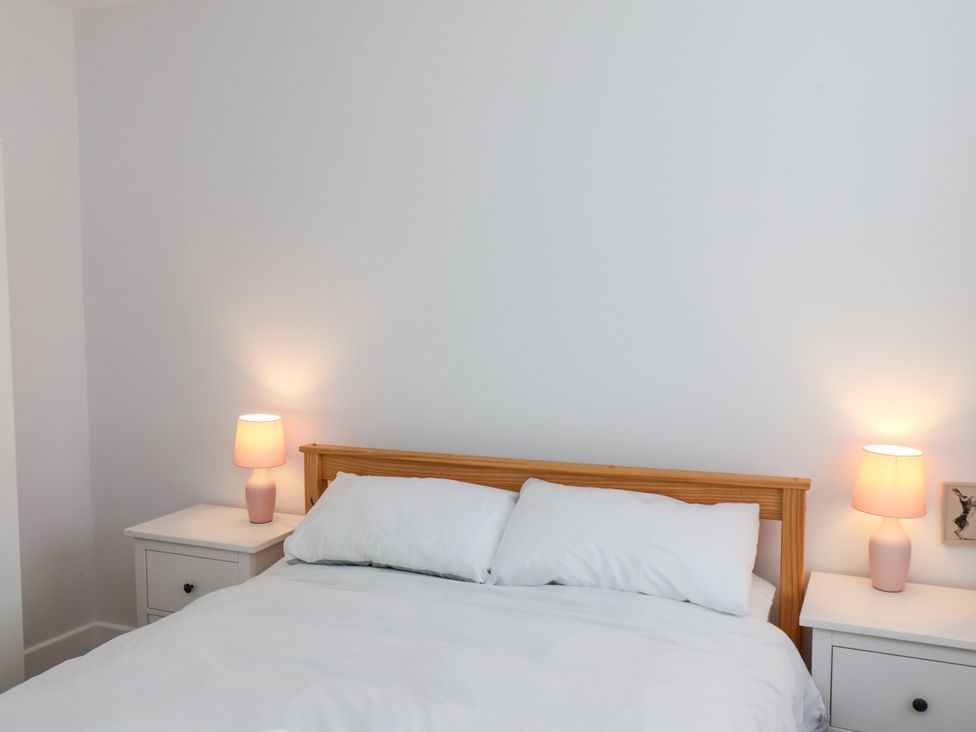 A bedroom with a bed and lamps on nightstands at 94 Church Street in Guisborough