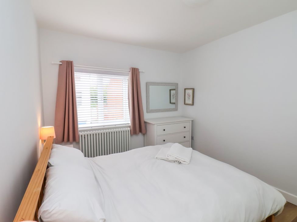 A bedroom with a bed, mirror, and wardrobe at 94 Church Street in Guisborough