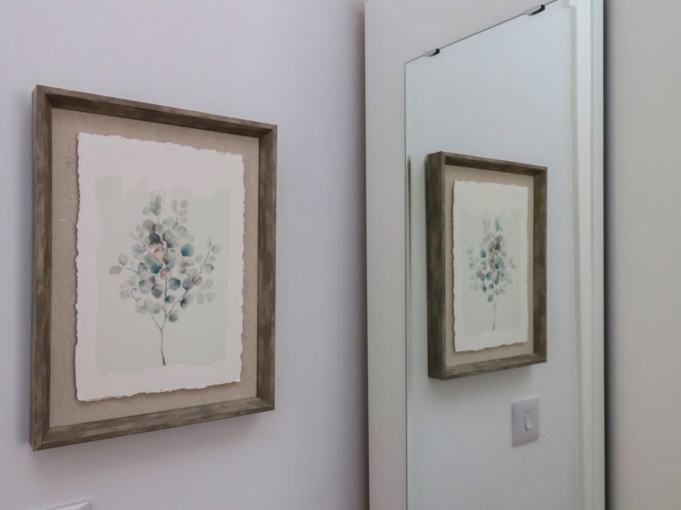 A framed artwork and a mirror in a bathroom at 94 Church Street, Guisborough