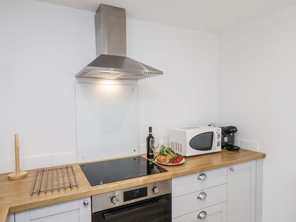 A kitchen with cooker, microwave, and utensils at 96 Church Street in Guisborough