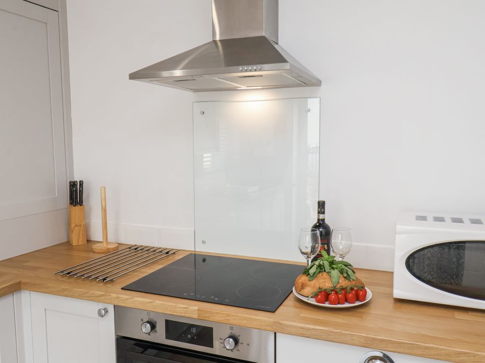 A kitchen with a cooktop and wine on the counter at 96 Church Street in Guisborough