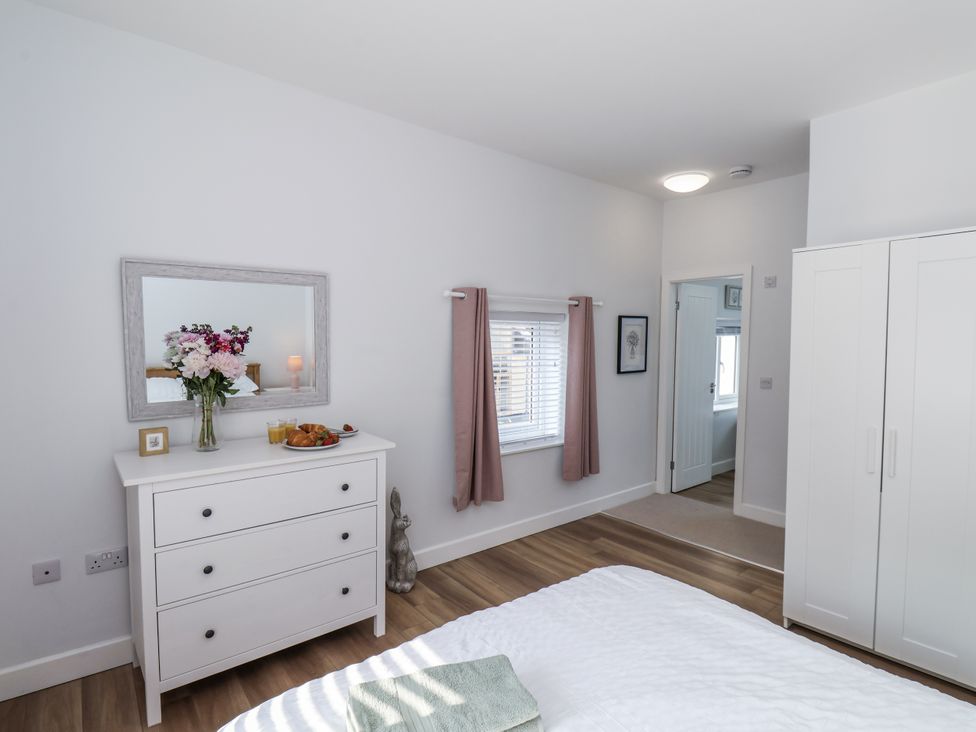 A bedroom with a dresser and flowers at 96 Church Street in Guisborough
