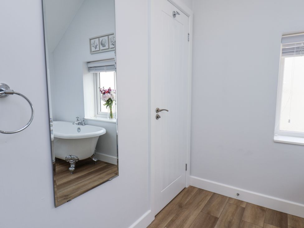 A bathroom with a bathtub and a mirror at 96 Church Street in Guisborough