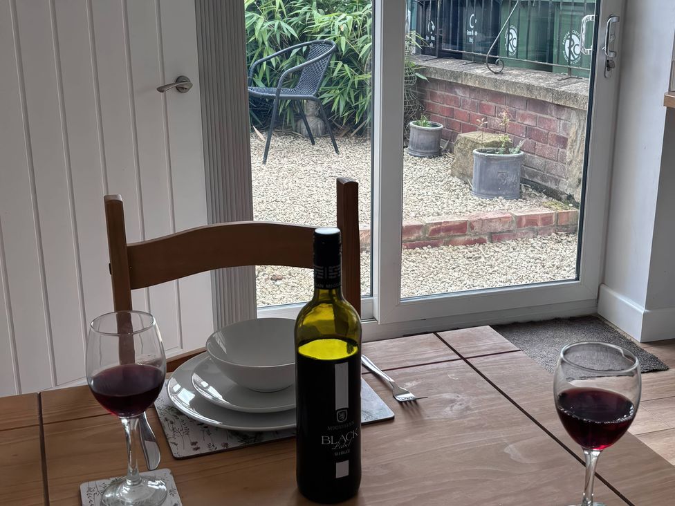 A dining area with a wine bottle and glasses at 96 Church Street in Guisborough