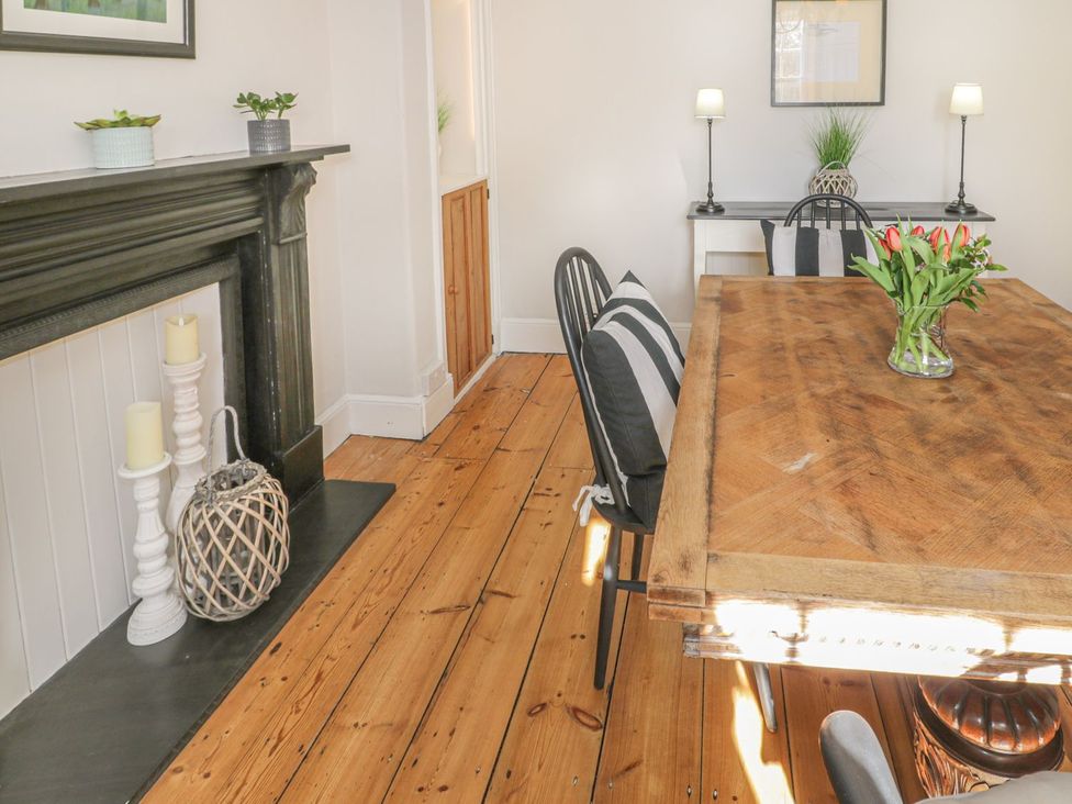 A dining room with a wooden table and plants at Bwthyn Morse Llanfair