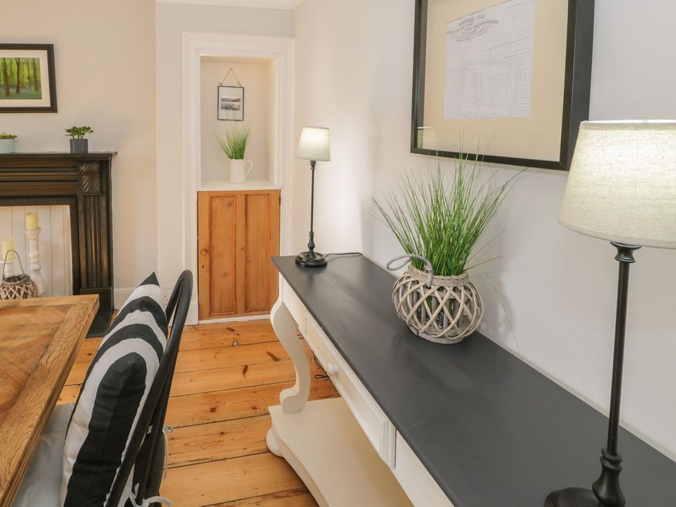 A dining room with a table and chairs at Bwthyn Morse in Llanfair