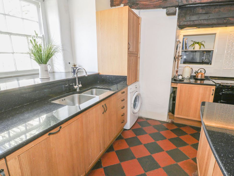 A kitchen with a sink and washing machine at Bwthyn Morse in Llanfair