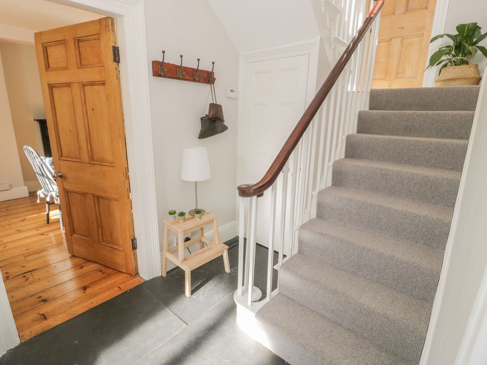 A hallway with a staircase and table at Bwthyn Morse in Llanfair