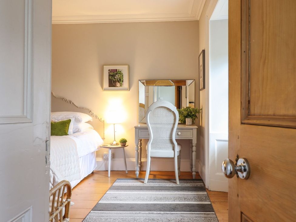 A bedroom with a bed and vanity at Bwthyn Morse in Llanfair