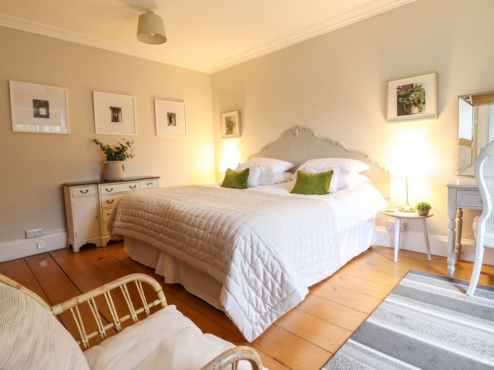A bedroom with a bed, nightstand, and chair at Bwthyn Morse in Llanfair