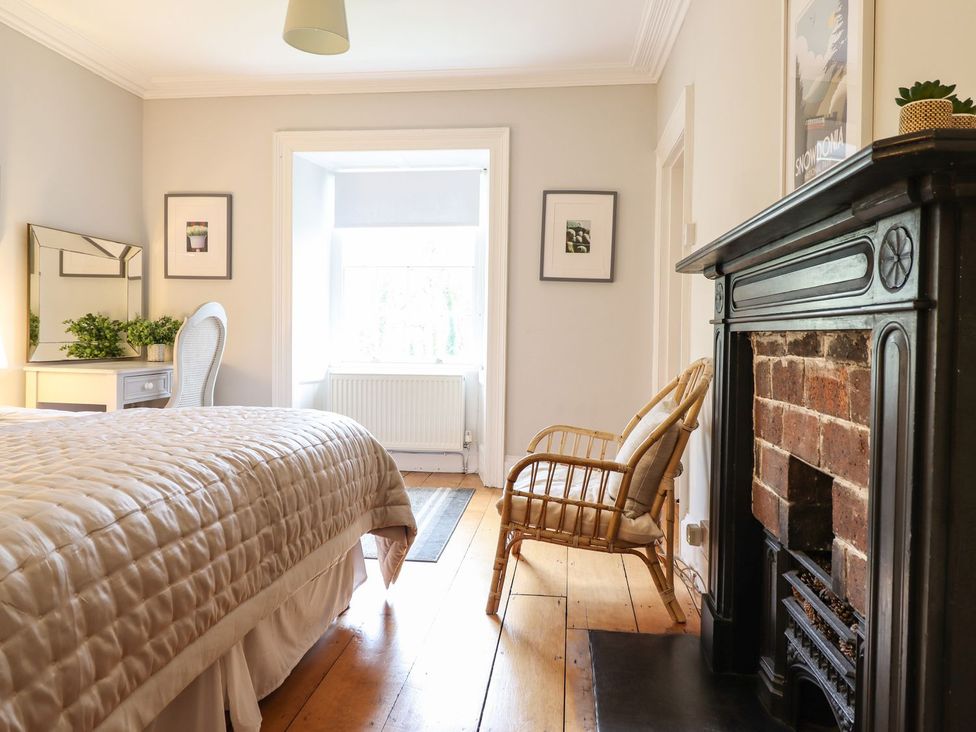 A bedroom with a bed and chair at Bwthyn Morse in Llanfair
