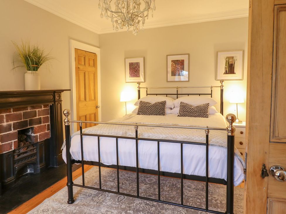 A bedroom with a bed and fireplace at Bwthyn Morse in Llanfair