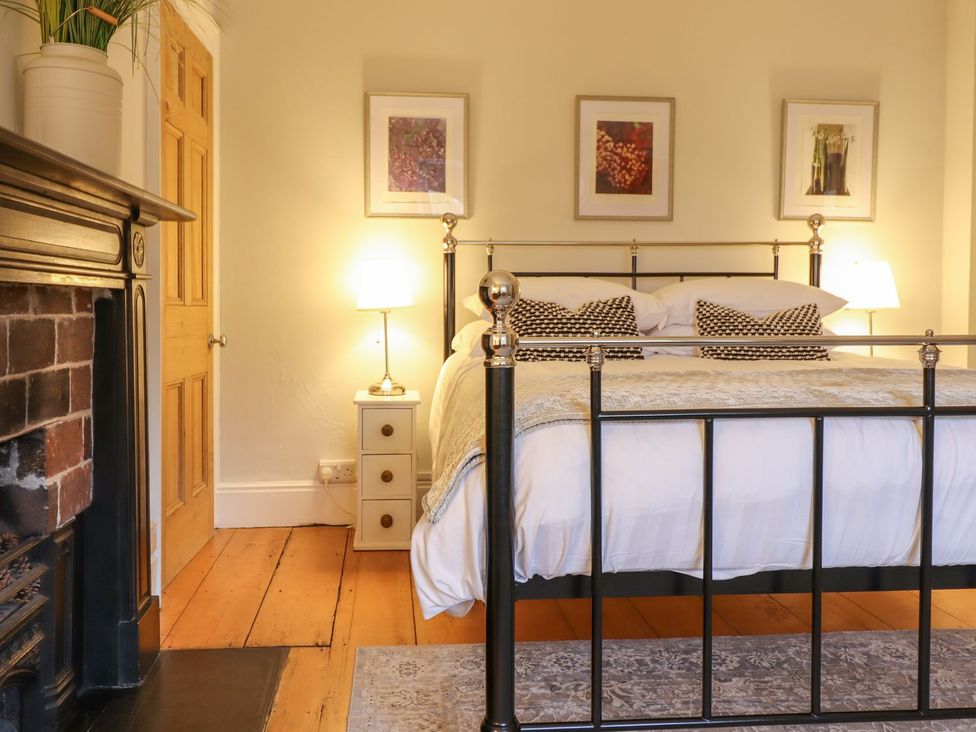 A bedroom with a bed and nightstand at Bwthyn Morse in Llanfair