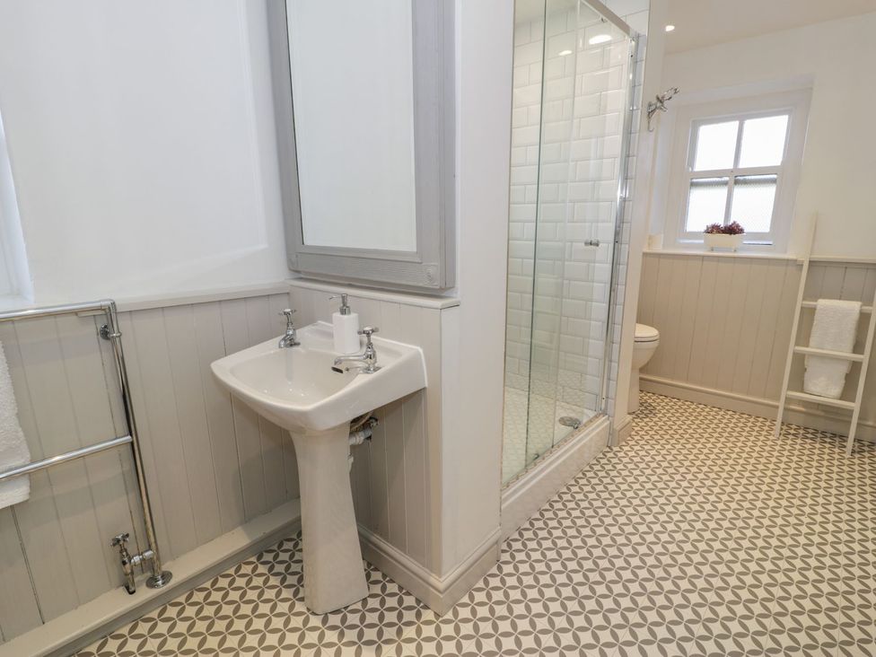 A bathroom with a shower, sink, and toilet at Bwthyn Morse in Llanfair