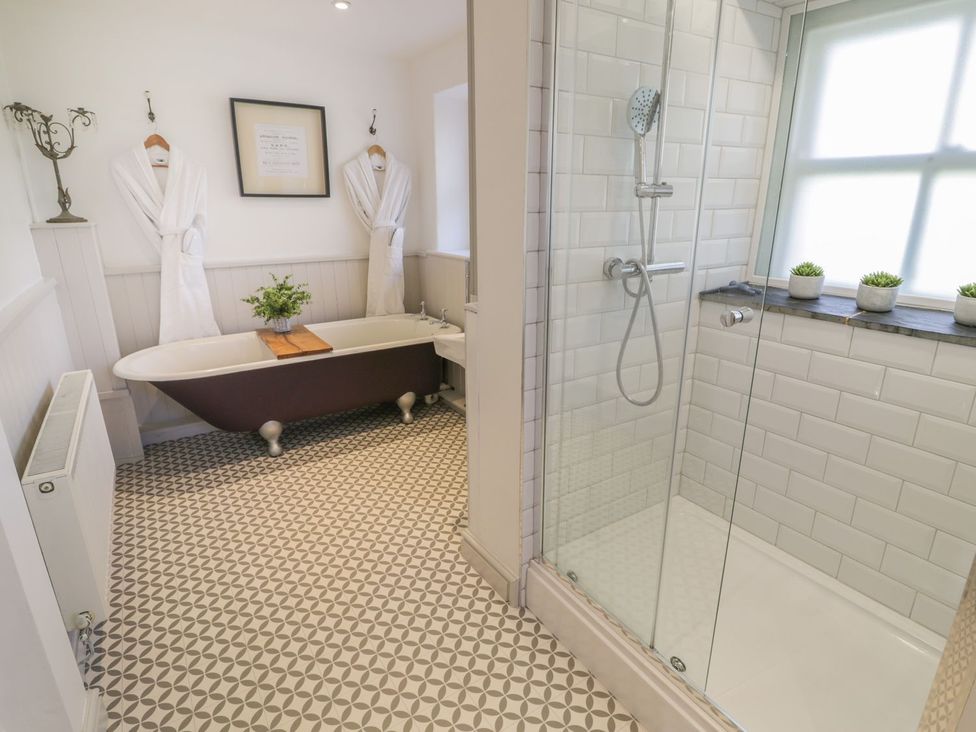 A bathroom with a bathtub and shower at Bwthyn Morse Llanfair