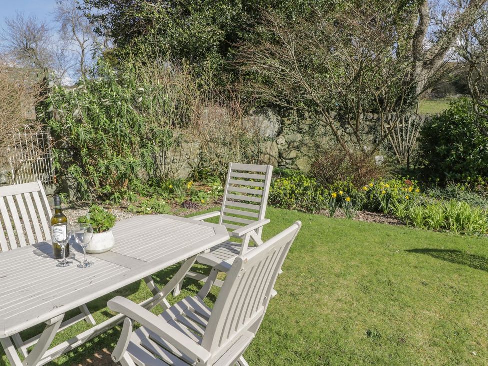 A garden with a wooden table and chairs at Bwthyn Morse in Llanfair