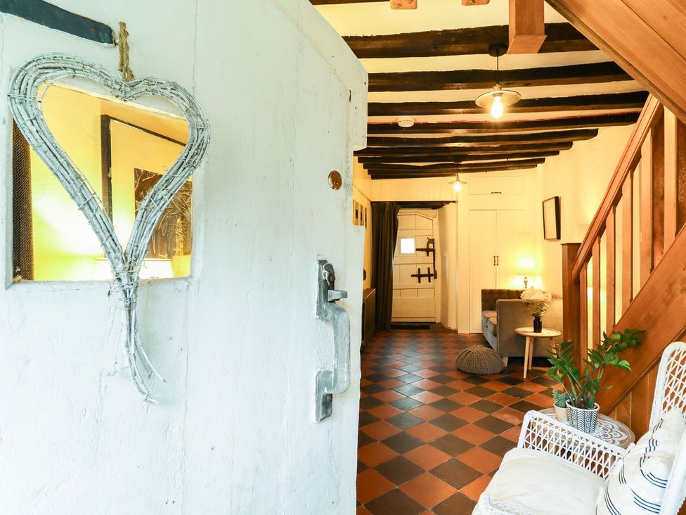 A hallway with a mirror and sofa at Bwthyn Canol in Llanfair