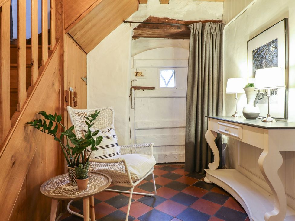 A hallway with a chair and table at Bwthyn Canol in Llanfair