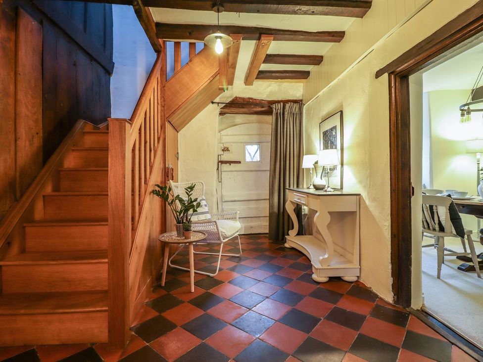 A hallway with a staircase and table at Bwthyn Canol in Llanfair