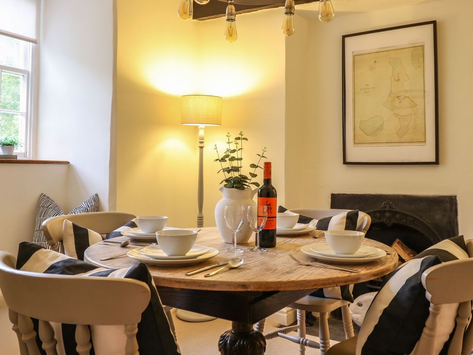A dining room with a table set for meals at Bwthyn Canol in Llanfair