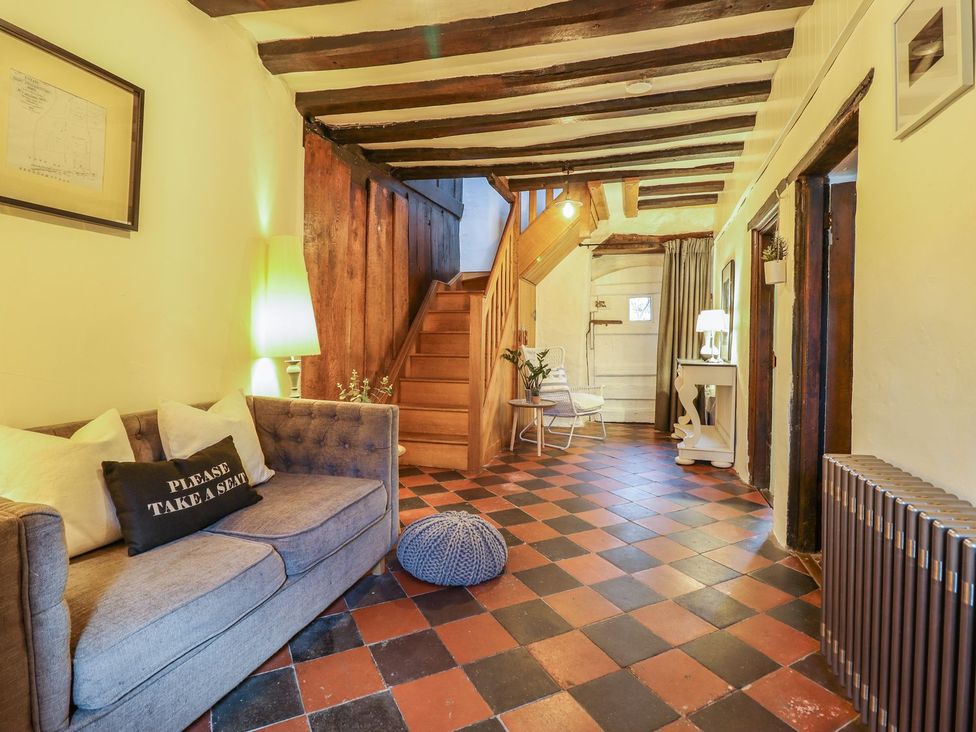 A hallway with a staircase and seating area at Bwthyn Canol in Llanfair