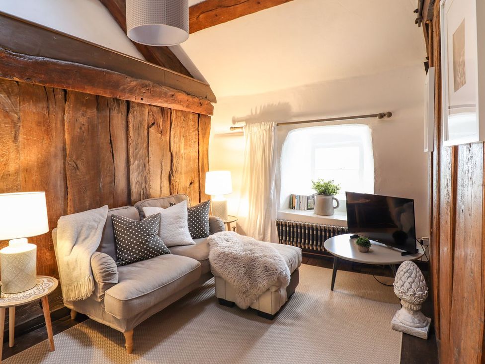 A living room with a sofa and a television at Bwthyn Canol in Llanfair