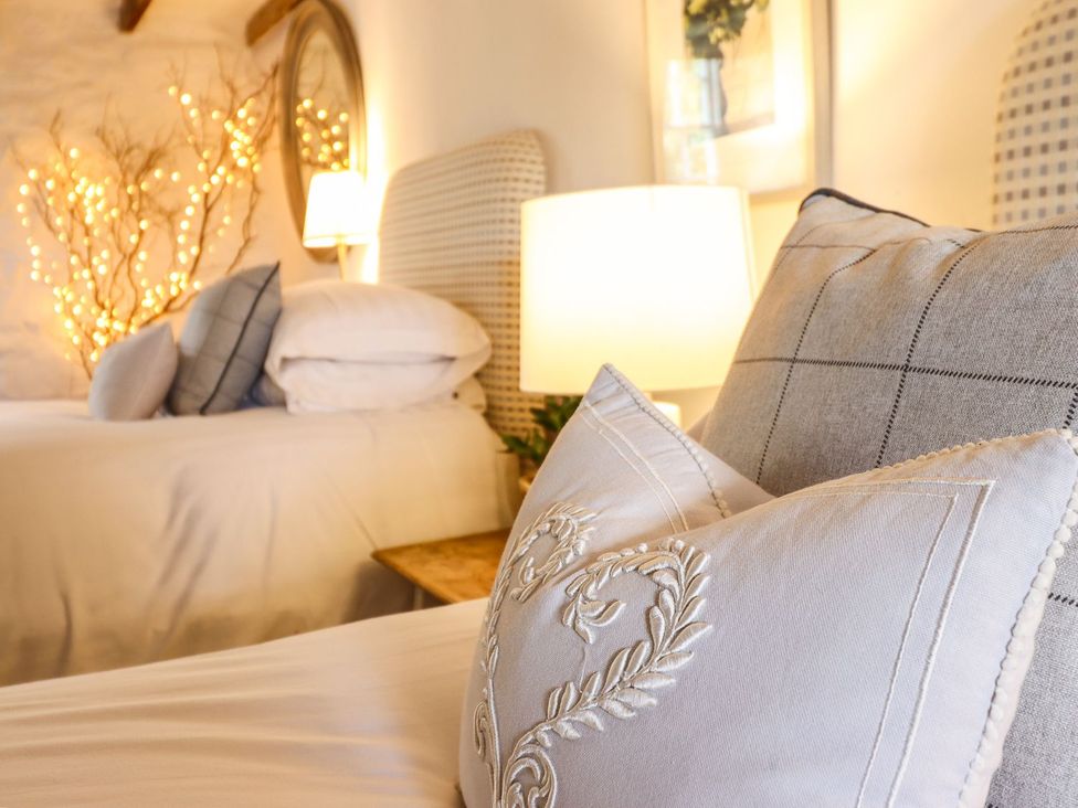 A bedroom with pillows on a bed and decorative lights at Bwthyn Canol in Llanfair