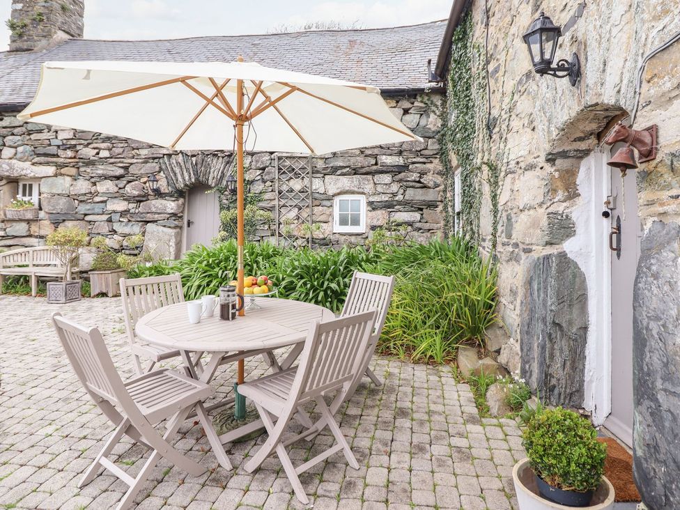 An outdoor patio with a table and chairs at Bwthyn Canol in Llanfair