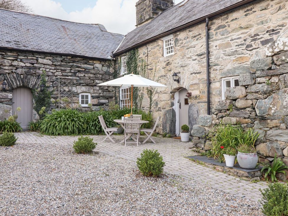 An outdoor seating area with a table and chairs at Bwthyn Canol in Llanfair