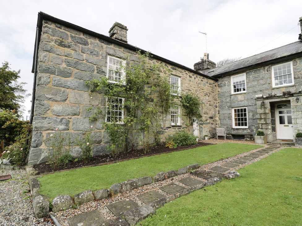 A stone house with a garden and pathway at Bwthyn Canol Llanfair