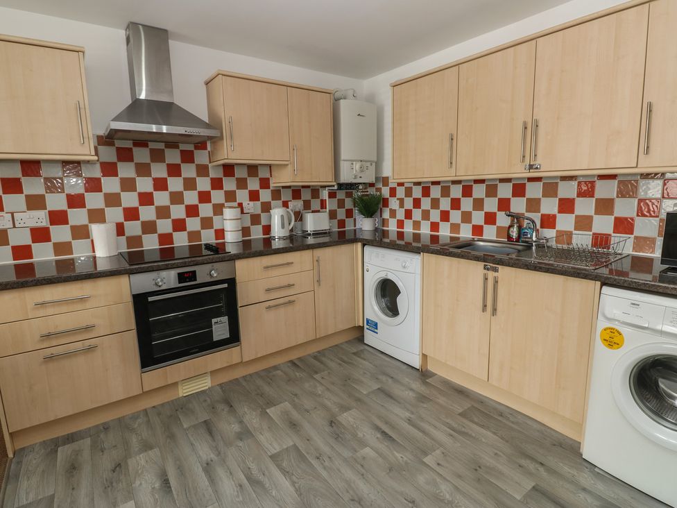 A kitchen with appliances at Curwen Apartment in Workington