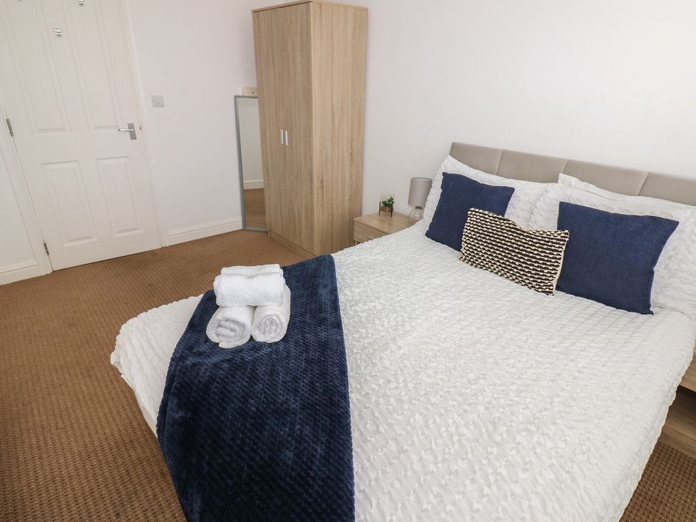 A bedroom with a bed and wardrobe at Curwen Apartment in Workington