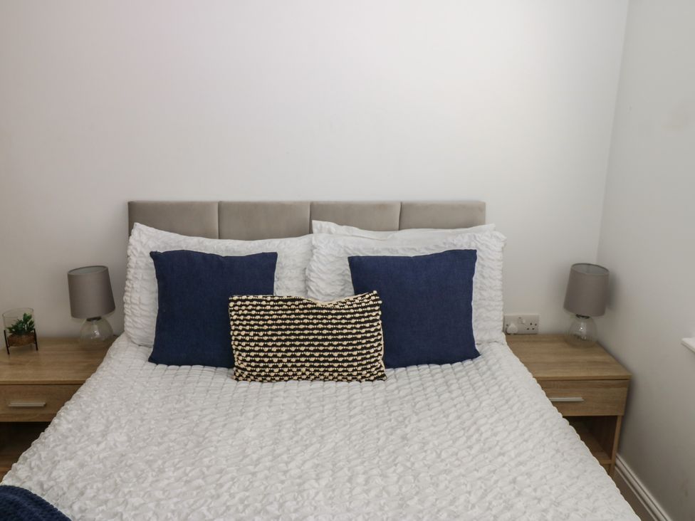 A bedroom with a bed and bedside tables at Curwen Apartment in Workington