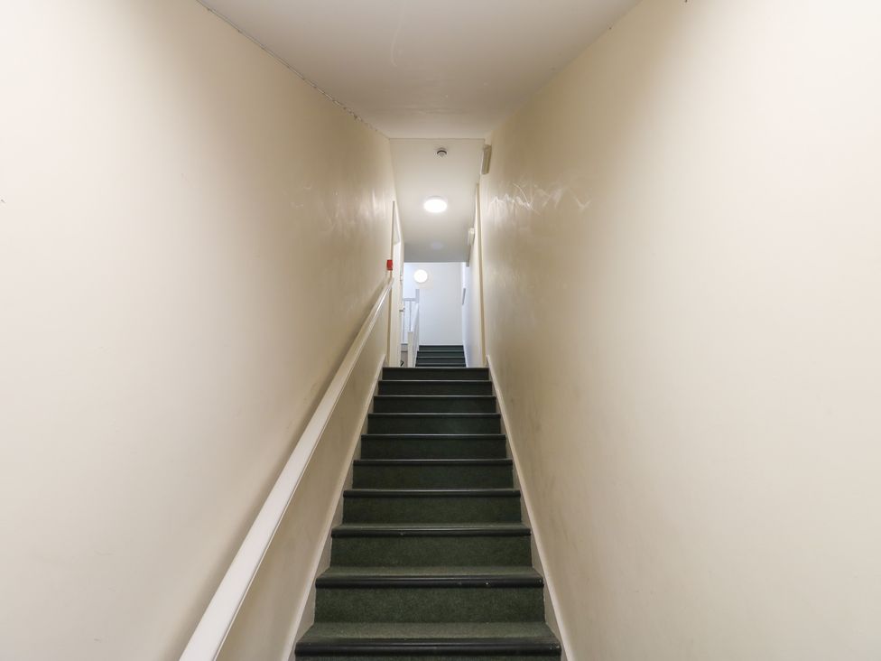 A staircase with stairs and a handrail at Curwen Apartment in Workington