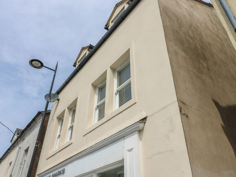 A building exterior with windows and a streetlight at Curwen Apartment in Workington
